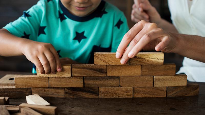 Lapsi leikkii puupalikoilla.