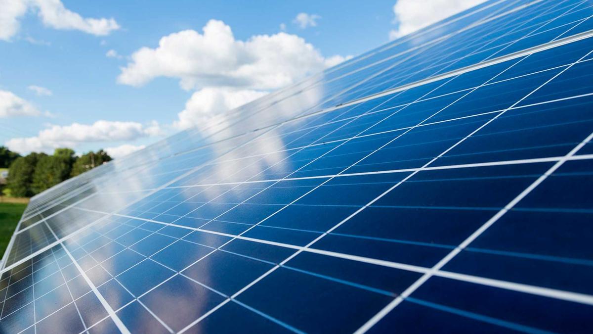 Aurinkopaneelikenttä kesäisessä maisemassa.