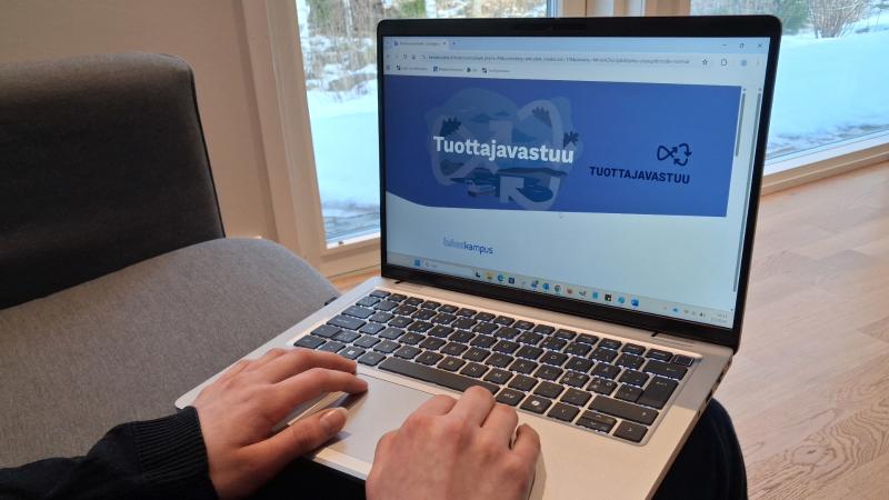 Kuvassa on kannettava tietokone ja kädet.